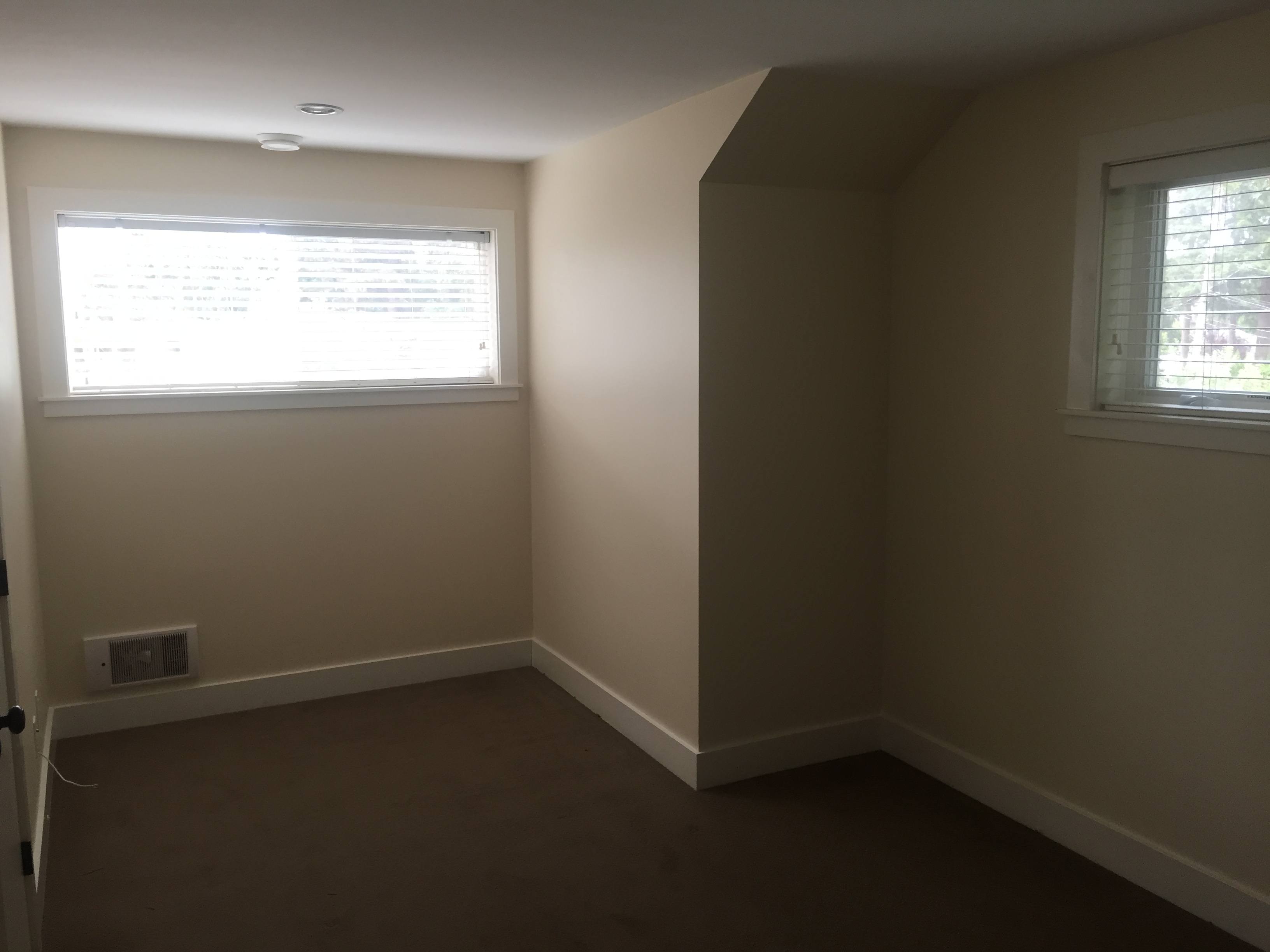 A room with a window and a wall socket.